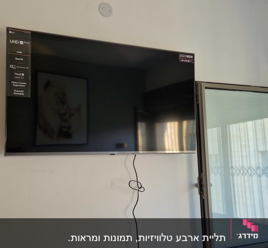 טלוויזיה מותקנת על הקיר עם כבל חשמל תלוי